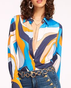 a woman with curly hair wearing a shirt and jeans