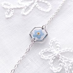 Thank you for visiting Fleur_Belles! This gorgeous silver Bracelet is made with Real Pressed flowers , Forget Me Not. They set in clear resin. Chain length: 14cm chain with 5cm extender Pendant size: 1.2cm x 1.2cm Sterling Silver version: It comes with Silver Polishing Cleaning Cloth.  🌺Due to the handmade nature of this product, slight variations may occur, however, the design remains as similar as possible. 💖CARE about the handmade accessories 💖 Please keep in a dry place and avoid prolonge Cheap Silver Jewelry With Pressed Flowers, Silver Birth Flower Bracelet As Gift, Silver Birth Flower Bracelets For Gifts, Silver Birth Flower Bracelets As A Gift, Hexagon-shaped Silver Jewelry For Gift, Silver Birth Flower Bracelet Jewelry, Handmade Hexagonal Silver Jewelry, Not Bracelet, Hexagon Bracelet