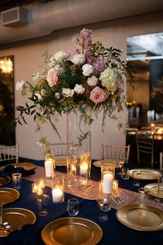 an elegant centerpiece with flowers and candles is displayed on a table set for dinner