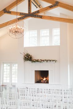 the ceremony room is set up with white chairs and chandelier hanging from the ceiling