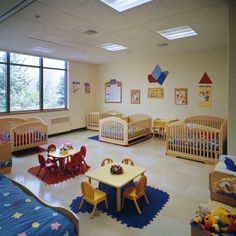 a child's room with cribs, tables, and chairs in it