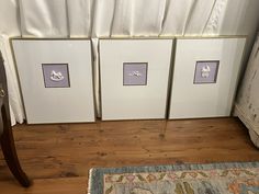 three framed pictures sitting on top of a wooden floor