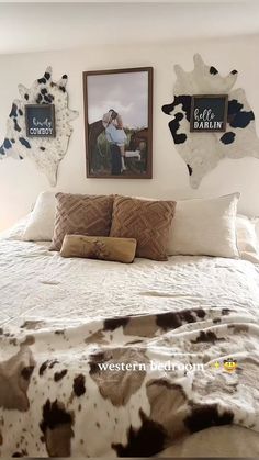 a bed with two cow prints on the wall above it