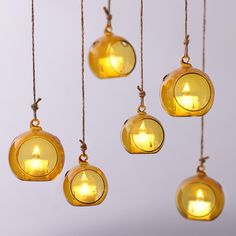 some yellow lights that are hanging in the air with strings attached to each light bulb