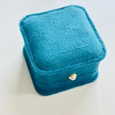 This beautiful velvet earring gift box comes in two stunning colors, peacock blue and grass green, and serves as a perfect jewelry case. The box features an elegant pearl adornment. The luxurious velvet material adds a touch of elegance to any gift, making it an ideal choice for special occasions. Keep your precious earrings safe and secure with this stylish and functional gift box. Dimensions: 6.5cm*6.5cm*4.9cm Weight: 60g Materials: Velveteen, imitation pearl Elegant Jewelry Storage With Dust Box For Gifts, Elegant Gold Jewelry Storage With Gift Box, Elegant Jewelry Storage Box Gift, Elegant Keepsake Jewelry With Gift Box, Luxury Turquoise Brooches For Gift, Ornate Peacock Design Necklace For Gift, Elegant Peacock-colored Earrings As A Gift, Blue Jewelry Box, Elegant Handmade Peacock-colored Jewelry