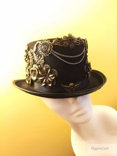 "Neo-Victorian top hat combining a vintage Victorian style with subtle eccentricity of mechanical aesthetic of steampunk, this unisex top hat is fitted with a variety of Victorian vintage baubles and fantastical cogs & gear ornaments on a formed Felt hat with with Ribbon Band. Choosing the custom theme Hat option? Whether you are a high-society aristocrat, a brilliant Steam engineer or a greasy Steam-machine mechanic, your customized hat will work wonderfully with almost any ensemble. S I Z Steampunk Fitted Brimmed Top Hat, Steampunk Top Hat With Curved Brim For Costume, Black Steampunk Top Hat For Alternative Fashion, Gothic Top Hat With High Crown, Gothic High Crown Top Hat, Gothic Fitted Top Hat With High Crown, High Crown Top Hat For Halloween, Gothic Fitted Hat With Curved Brim, Gothic Fitted Hats With Curved Brim