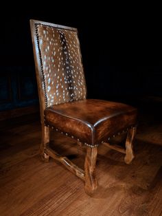 a wooden chair sitting on top of a hard wood floor next to a black wall