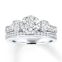 a white gold ring with three diamonds on the side and two rows of round brilliant cut diamonds in the middle