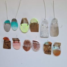 several different colored earrings hanging from strings