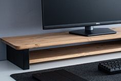 a computer monitor sitting on top of a wooden shelf next to a keyboard and mouse