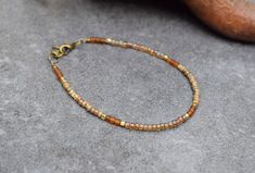 Dainty bohemian bracelet with rustic tiny beads and warm brown colors.  A lovely piece that is easy to combine and perfect to add to your everyday outfit. She will also make a unique gift for the Holidays! Here you find the matching necklace: https://etsy.me/3iqeBDN I mixed opaque and translucent colors to create a color block design. Note that the beads in this bracelet have an earthy Picasso finish, giving them an aged appearance. In between I used irregular frosted brown beads that add to the rustic look. The tiny gold brass cube beads are handmade in Ethiopia. They create a subtle bohemian sparkle. - The bracelet is finished with an extension chain of approx. 1 inch (3 cm) - I used high quality Miyuki glass seed beads of 3 mm (size 8/0). Precision-made in Japan, and among some of the f Minimalist Brown Bracelets With Round Beads, Hippie Bracelet With Colorful Beads, Hippie Brown Bracelet With Colorful Beads, Everyday Brown Bracelets With Colorful Beads, Bohemian Brown Friendship Bracelets With Colorful Beads, Rustic Brown Beaded Bracelets For Festival, Hippie Brown Round Bead Bracelets, Hippie Style Brown Hand-strung Beaded Bracelets, Brown Bohemian Bracelets For Everyday