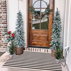 the front door is decorated with christmas trees and wreaths