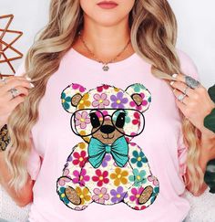 Colorful Daisy Teddy Bear (Tee) | Spring Fashion | Unisex Pre-Shrunk T-Shirt   Embrace the spirit of spring with our vibrant color palette, featuring pastel hues and refreshing tones that capture the essence of nature's awakening. Whether you're strolling through blooming gardens or enjoying a picnic in the park, our adorable and chic spring t-shirts will effortlessly elevate your spring wardrobe.   Key Features: High-Quality Material: Made from the softest washed, garment-dyed, and durable fabric, this T-shirt is built to last and keep you comfortable all day. Unisex Design: Embrace inclusivity with our unisex designs, catering to all body types and styles. Charming Appeal: Our adorable spring t-shirts are made for our retro and groovy brand! This design is composed of distressed, grunge, Spring T Shirts, Picnic In The Park, Pastel Hues, Spring Wardrobe, Unisex Design, The Park, Clothing Items, Spring Fashion, Favorite Outfit