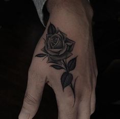 a hand with a rose tattoo on it