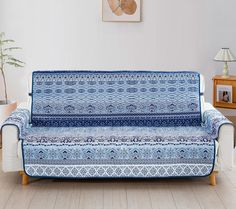 a blue and white couch sitting on top of a hard wood floor