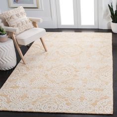 a white chair sitting on top of a wooden floor next to a beige area rug