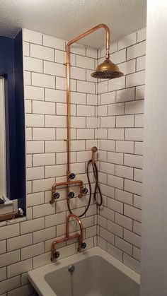 a bathroom with a tub, shower head and hand held faucet in it