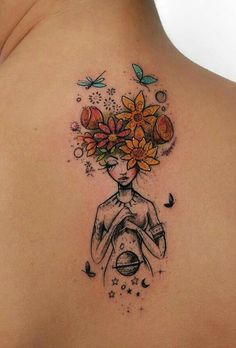 a woman's back with flowers and butterflies in her hair on top of her shoulder