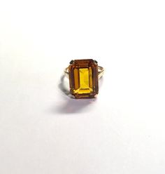 Large Yellow Emerald Cut Rectangle Citrine Gemstone 4 Prong Solitaire Ring Size 9 Metal: 10k yellow gold, (acid tested) Weight: 7.2 grams Ring Size: 9 (can be resized upon request) Size: Sits 10mm off finger, 2mm shank Stone: 18.50 x 13.50mm emerald cut rectangular citrine gemstone Hallmarked: makers mark November birthstone This is an estate piece in excellent pre-loved condition. Please see pictures for reference. Fine Jewelry Yellow Gold Octagon Topaz Ring, Yellow Gold Octagon Topaz Ring, Yellow Gold Octagon Topaz Ring Fine Jewelry, Yellow Emerald-cut Topaz Ring, Yellow Gold Octagon Topaz Ring In Fine Jewelry Style, Formal Yellow Gold Topaz Ring With Rectangular Stone, Rectangular Yellow Gold Topaz Ring, Yellow Gold Rings With Rectangular Accent Stones, Rectangular Topaz Ring In Yellow Gold