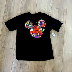 Disney, Walt Disney World Parks, Happy Halloween T-Shirt, New With Tags, Black T-Shirt With Adorable Mickey Ears With Happy Halloween And A Graphic Print On The Front, On The Side Is Walt Disney World And Embroidery, Size Medium Disney Halloween Graphic Print T-shirt, Black Disney T-shirt For Disney Trips, Disney Halloween Cotton T-shirt, Black Disney T-shirt For Fall, Black Disney T-shirt For Fan Events, Disney Halloween T-shirt, Disney Halloween Short Sleeve Tops, Black Themed T-shirt For Disney Fan Events, Themed Black T-shirt For Disney Fan Events