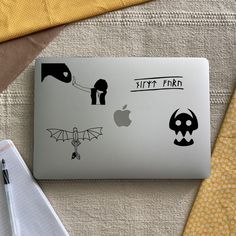 an apple laptop sitting on top of a table next to a white napkin and yellow cloth