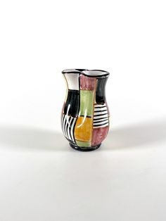 a multicolored vase sitting on top of a white table