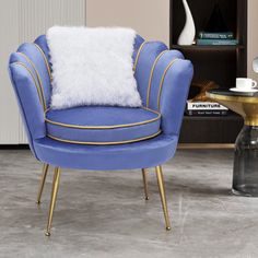 a blue chair with a white pillow sitting on top of it next to a table