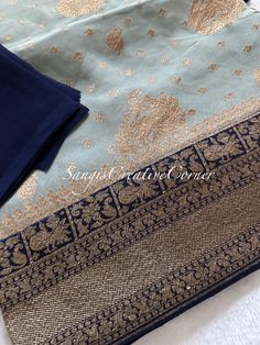 WELCOME to Sangi's Ancient threads where you step into elegance with any of our handlooms and hand embroiled pieces.  The an unique and rare color combination- storm blue/grey with an antique border (navy blue) combo! This is a pure and beautiful Khaddi Georgette silk woven (see below for the history) silk saree with vibrant weaving all through out the saree with small buttis and border of the saree is a an antique zari with dark navy blue hues within the border. The intricate gold work weaved t Elegant Banarasi Silk Sets With Zari Work, Elegant Blue Sets With Zari Weaving, Elegant Blue Banarasi Silk Set, Elegant Blue Unstitched Suit With Self Design, Unstitched Banarasi Silk Sets, Unstitched Elegant Banarasi Silk Sets, Elegant Unstitched Banarasi Silk Sets, Elegant Unstitched Suit With Cutdana For Celebration, Elegant Designer Unstitched Suit With Zari Weaving