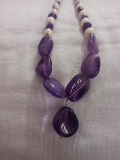 Amethyst Necklace Smooth AAA Tumble Beads With Center Tumble Gemstone 20 inch Necklace Stone : Natural Amethyst Fresh Water Pearl Shape :- Tumble Size :- 7x7-14x18mm 1. Weight :- 237 carat With Amethyst Tumble, 20 INCH Necklace Polish :- Handmade Purity :- 100% Natural Gemstone color - white blue It is known as the 'love stone' as the message it emits is the strong vibration of unconditional love, joy, warmth and healing. As quartz crystals are profound amplifiers of energy, it may help to kindl Purple Polished Beads Necklace As Gift, Purple Polished Beads Necklace For Gift, Healing Amethyst Necklaces With Polished Beads, Healing Amethyst Necklace With Polished Beads, Polished Tumbled Bead Necklaces As Gifts, Tumbled Polished Beads Necklace For Gifts, Tumbled Polished Bead Necklaces For Gifts, Purple Beaded Necklaces With Stones For Gifts, Gift Necklaces With Large Rondelle Beads