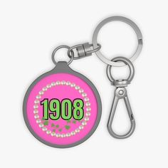 a pink keychain with the word 1908 printed on it