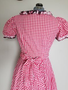 "Super adorable 1950's western style dress. This would be perfect for a dancing date! Or Valentines day! The dress has a fitted bodice with a side metal zipper and an 8 paneled circle skirt with some gathers. The dress also comes with a sash that can be tied around the waist or used as a hair decoration. Sleeves are puffed and there is black ric-rac trim adorning all the ruffles. Condition: Great vintage condition. General, minor signs of wear. I found two very small slight spots of discoloratio Fitted Retro Vintage Dress For Picnic, Fitted Gingham Retro Vintage Dress, Fitted Vintage Gingham Dress In Retro Style, Fitted Gingham Vintage Dress, Retro Fitted Gingham Vintage Dress, Vintage Fitted Dress For Picnic, Fitted Retro Plaid Vintage Dress, Fitted Plaid Retro Vintage Dress, Retro Plaid Fitted Vintage Dress