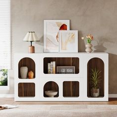 a living room with a white and brown bookcase on top of a wooden floor