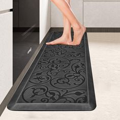 a person stepping on a mat in a kitchen