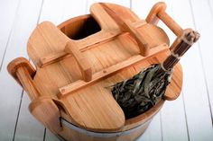 a wooden container filled with green tea leaves