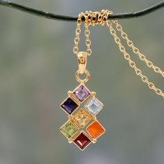 A colorful gemstone grid aligns with chakra energies to achieve a harmonious sense of well-being. From Alok Jain in India the 22k gold plated necklace glistens with amethyst iolite citrine peridot garnet blue topaz and carnelian. Their colors each correspond to a specific chakra. Clear and light purple stones are associated with the 7th chakra (awareness and wisdom); the purple violet and indigo gems with the 6th chakra (insight and perception) and the blue or light blue with the 5th that of com Necklaces Amethyst, Necklaces Gemstone, Orange Gem, Yellow Gems, Heart Shaped Pendant Necklace, Colorful Necklace, Black Gems, Gemstone Pendants, Pendant Heart