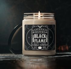 a candle is sitting on a table with a black flame in front of the candle