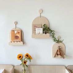 three wooden shelves on the wall with flowers in vases