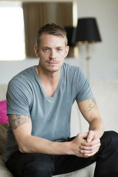 a man sitting on top of a couch next to a lamp