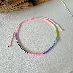 - Dive into the vibrant joy of summer with our artisanal baby pink corded anklet, a piece that encapsulates the essence of beach vibes and festival euphoria. Each anklet is meticulously handcrafted, featuring an enchanting array of Miyuki beads in shades of purple, clear, black, white, neon pink, blue, green, and salmon, crowned with a blue rondelle shell charm that whispers the secrets of the ocean. - Adjustable for comfort, this anklet promises a perfect fit for every adventurer. Its joyful pa Jewelry Purple, Beach Festival, Blue Shell, Festival Jewelry, Miyuki Beads, Anklet Jewelry, Body Jewellery, Shades Of Purple, Neon Pink