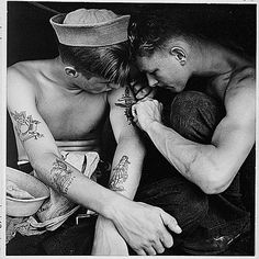 two men with tattoos sitting next to each other