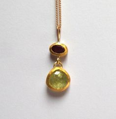 Garnet and Peridot pendant - Beautiful Garnet and Peridot stones inlaid in 24k gold. The Garnet stone size is 4/6mm. The Peridot stone size is 9mm. The Garnet and Peridot pendant length 23mm. The Garnet and Peridot pendant on oxidized sterling silver chain 50cm - 350$. The Garnet and Peridot pendant on 14k solid gold Chain in length 45cm - 530$. Please let me know how do you want the Garnet pendant. Free Shipping The pendant will be packed in a Beautiful gift box. Your necklace will be shipped t Luxury Gold Peridot Jewelry, Luxury Gold Jewelry With Peridot, 22k Gold Gemstone Pendant Necklace, Gold Peridot Gemstone Jewelry, Gold Peridot Jewelry With Gemstone, Fine Jewelry In Gold With Peridot, Gold Peridot Fine Jewelry, Fine Jewelry Gold Peridot, Fusion Gold Necklaces With Natural Stones