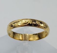 a gold wedding ring with leaves on it