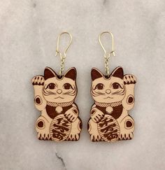 "These Maneki Neko earrings will make a fun addition to your wardrobe or a great gift for people who love everything Japanese or someone starting a business! Now available in clear acrylic! Maneki Neko are traditionally Japanese lucky cat figures that are used for luck in businesses. One earring features a cat with his right paw raised to bring in more money and one earring features a cat with its left paw raised to bring in customers. Graphically designed and then engraved and cut using a laser Cat Design Earrings With Cat Ears For Gifts, Cat Design Earrings With Cat Ears Shape For Gift, Cat Design Earrings With Cat Ears, Cat Design Drop Earrings As A Gift, Cat Design Dangle Earrings For Gift, Cat Design Drop Earrings For Gift, Kawaii Cat Ears Jewelry For Gift, Dangle Earrings With Cat Design For Gifts, Nickel-free Cat Ears Earrings As Gift