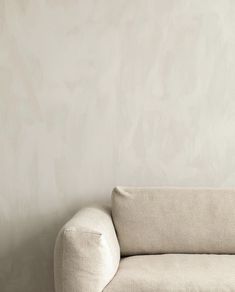 a white couch sitting in front of a wall