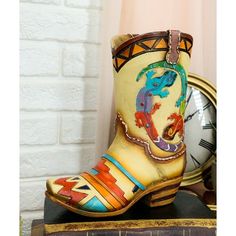 This cowboy/cowgirl boot sculpture is made of high quality polyresin, hand painted and polished individually.  This cowboy/cowgirl boot sculpture measures approximately 7" tall, 6" wide and 2.5" deep each. It weighs about 13 ounces.  Our curated collection of boots present quality, affordable luxury designer bedroom, bath, kitchen, and home dcor designs that exemplify the rustic western style! This ornate boot is perfect as a sculptural decor or as planter/vase for your flowers/plants!  Props in Multicolor Western Festival Boots, Multicolor Western Boots For Festivals, Bouquet Vase, Feather Wall Hanging, Feather Dream Catcher, Cowgirl Boot, Cowgirl Cowboy, Beaded Rope, Cowboy Cowgirl