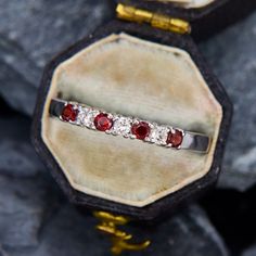 This touch-of-sparkle ring has alternating round garnets and round brilliant cut diamonds set across the top of the piece. It would be a great gift for a January birthday or someone who loves the deep dramatic red of garnets. The ring is crafted in 14k white gold and is currently a size 8.75. Classic Red Diamond Ring With Single Cut Diamonds, Classic Round Half Eternity Ruby Ring, Formal Round Half Eternity Birthstone Ring, Classic Round Ruby Ring With Half Eternity Band, Formal Half Eternity Birthstone Ring - Round Shape, Formal Ruby Ring With Single Cut Diamonds, Red Diamond Ring With Single Cut Diamonds For Anniversary, Anniversary Ruby Ring Half Eternity Style, Ruby Ring With Diamond And Birthstone