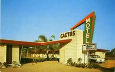 an old motel with a car parked in front of it and palm trees around the building