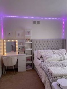 a white bed sitting next to a desk with a mirror on it's side