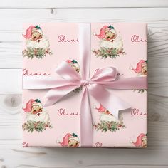 a pink wrapping paper with santa claus on it and a bow around the wrapper