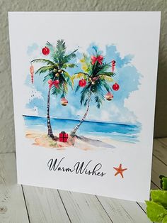 a greeting card with two palm trees on the beach and presents in boxes under them